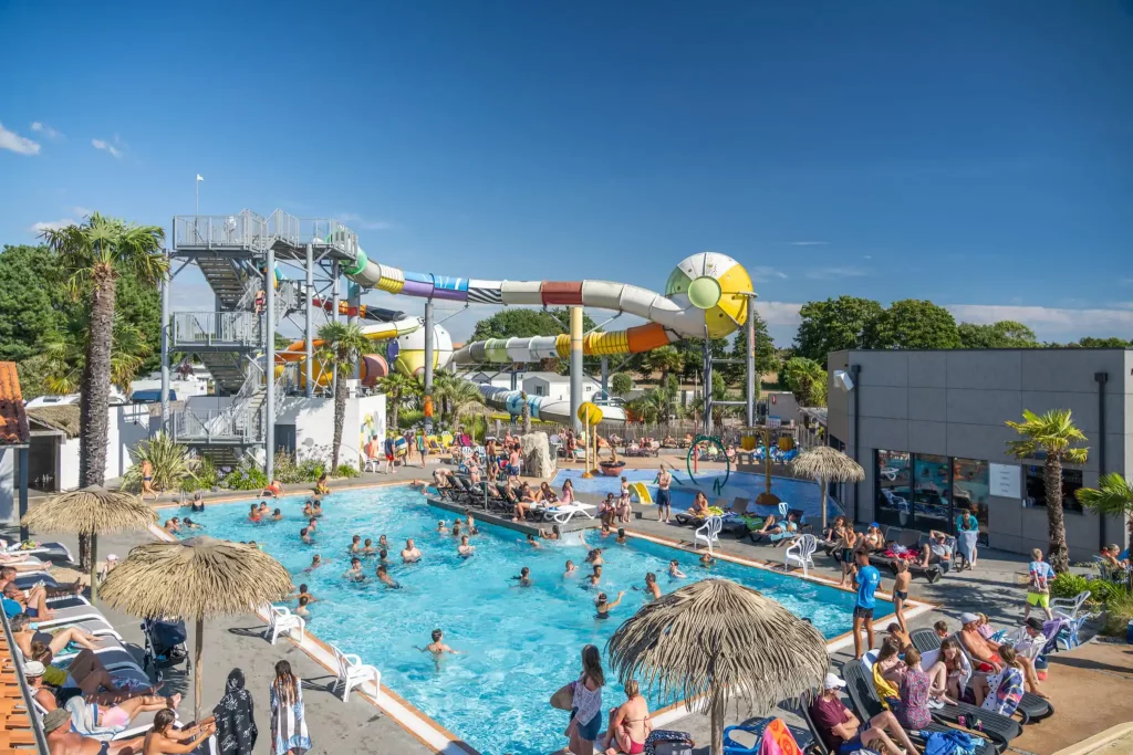 Piscine extérieure dans un camping 5 étoiles à Saint-Hilaire-de-Riez, avec transats et espace aquatique sous le soleil.