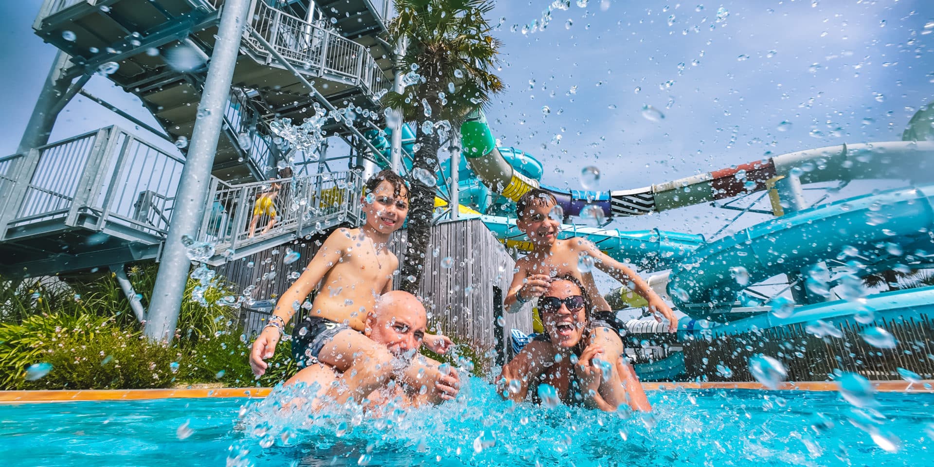 Famille s’amusant et s’éclaboussant dans la piscine du Camping Le Château à Saint-Hilaire-de-Riez