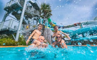 Famille s’amusant et s’éclaboussant dans la piscine du Camping Le Château à Saint-Hilaire-de-Riez